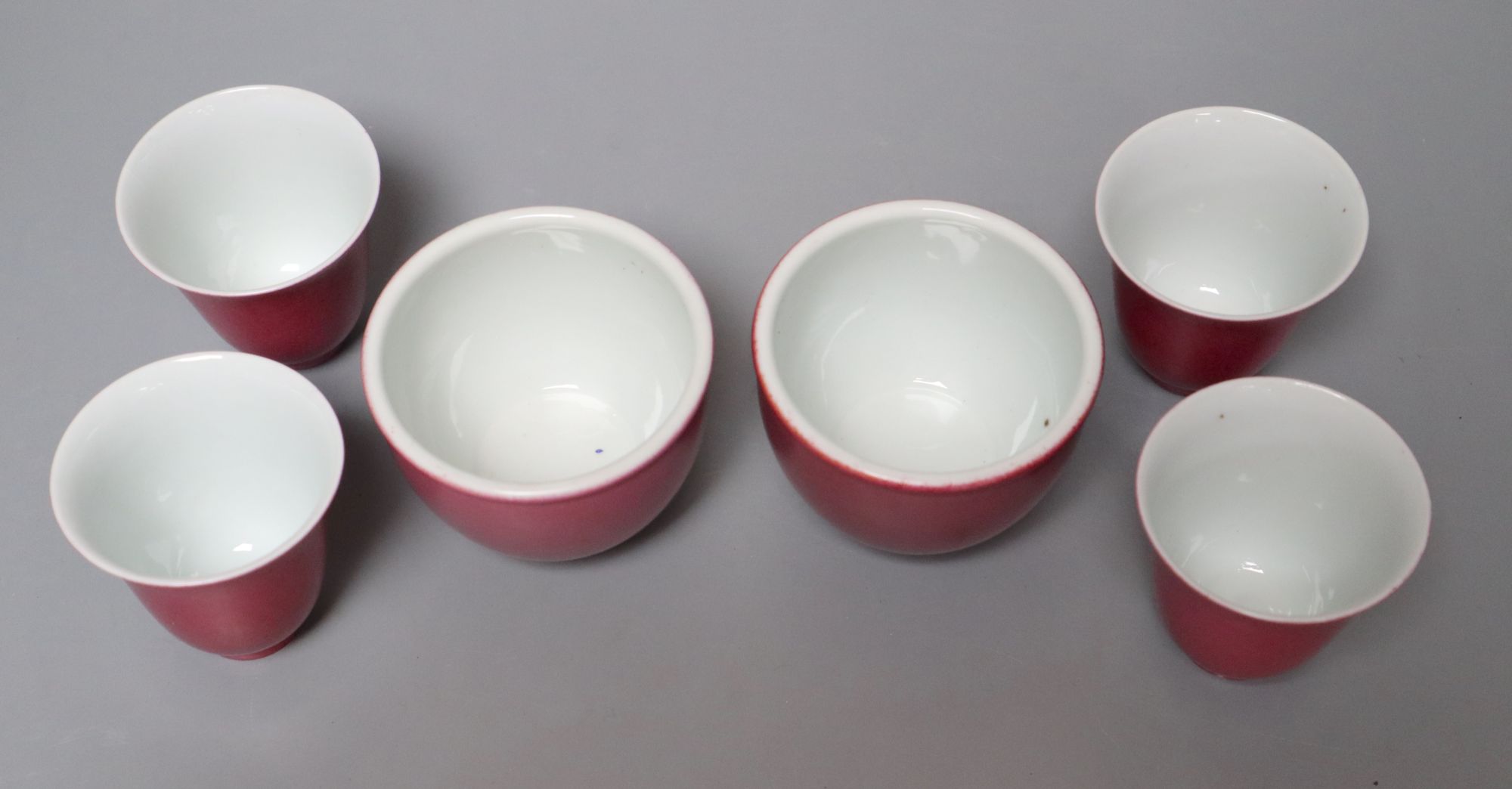Four Chinese ruby ground tea cups and a pair of similar pots, height 6cm